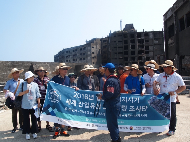 지난달 26일 일본 하시마 일명 군함도에서 일본 메이지시기 세계 산업유산 모니터링 조사단이 현수막을 내걸고 사진 촬영을 하려하자 현지 안내원이 이를 제지하고 있다. 조사단 제공