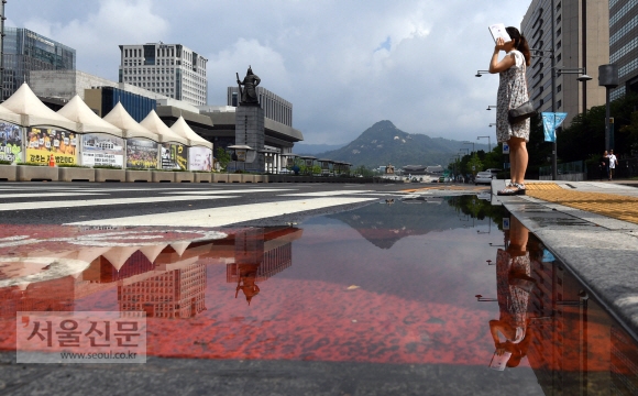 5일 서울 광화문 네거리에서 시민들이 소나기로 인해 생긴 물웅덩이를 지나고 있다.2018. 8. 5. 박윤슬 기자 seul@seoul.co.kr