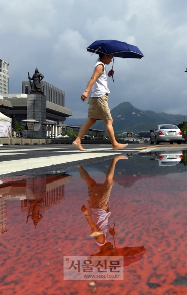 5일 서울 광화문 네거리에서 시민들이 소나기로 인해 생긴 물웅덩이를 지나고 있다.2018. 8. 5. 박윤슬 기자 seul@seoul.co.kr