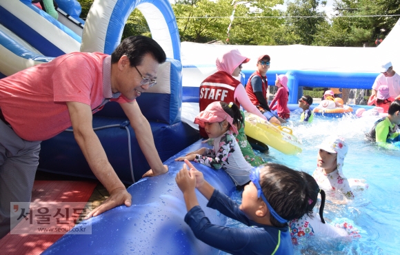 성장현(왼쪽) 서울 용산구청장이 지난달 30일 응봉공원에 마련된 ‘어린이 물놀이장’을 방문해 어린이들과 이야기를 나누고 있다.  최해국 선임기자 seaworld@seoul.co.kr