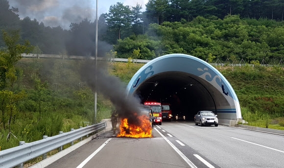 12일 오전 9시 15분께 강원 양양군 서면 수리 인근 서울양양고속도로 서면 7터널 출구에서 안모(70·경기 의정부)씨가 몰던 스타렉스 승합차에서 불이 나 소방대원 등이 진화하고 있다. 승합차에는 안씨 등 피서객 9명이 타고 있었으나 불이 나자 신속히 대피해 인명피해는 없었다. 2018.8.12  강원도 소방본부 제공