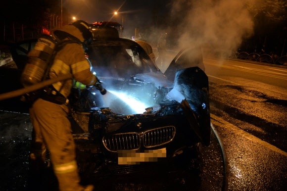 지난 12일 밤 경기도 하남시 미사대로에서 주행 중이던 BMW 차량에서 불이나 신고를 받고 출동한 소방대원들이 진화하고 있다. 하남소방서 제공
