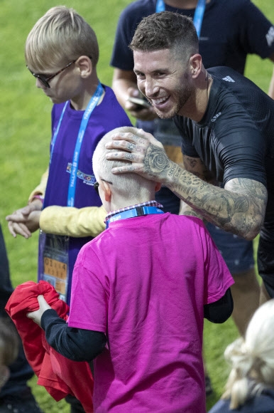 스페인 프로축구 레알 마드리드의 주장 세르히오 라모스가 유럽축구연맹(UEFA) 슈퍼컵 대결을 하루 앞둔 14일(현지시간) 에스토니아 탈린의 릴레퀼라 스타디움에서 훈련을 갖기 전 시각장애 어린이의 머리를 쓰다듬고 있다. 탈린 AP 연합뉴스