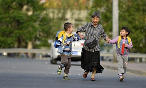 56살에 시험관 시술로 쌍둥이를 낳은 궈민이 베이징에서 자녀들의 등교를 돕고 있다. 출처: 글로벌타임스