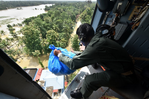 인도군 병사가 19일(현지시간) 인도 남부 케랄라주에서 홍수 이재민들에게 생필품을 투하하고 있다.=첸간누르 AP 연합뉴스