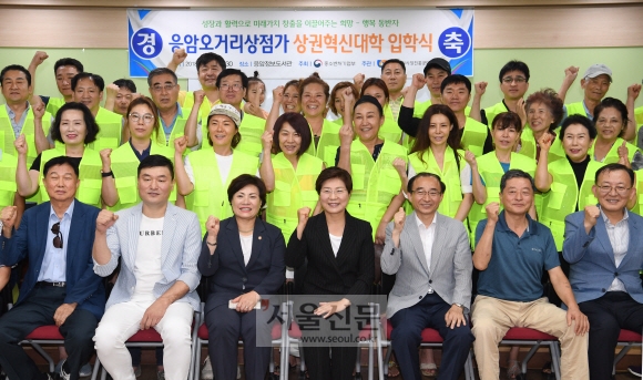 김미경(왼쪽 네 번째) 은평구청장이 지난 16일 구립응암정보도서관에서 응암오거리상점가 상권혁신대학 입학식에 참석해 상인들과 파이팅을 외치며 기념촬영을 하고 있다.  김명국 선임기자 daunso@seoul.co.kr