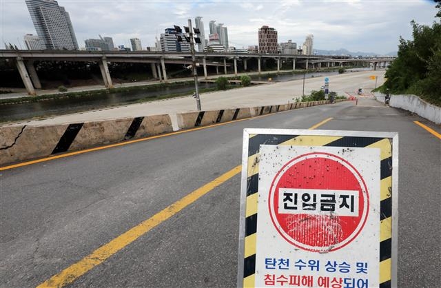 23일 서울 탄천주차장 인근 도로에 침수피해를 막기 위해 ‘진입금지’ 표지판이 세워져 있다.  뉴스1