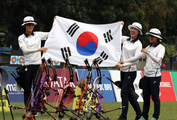 한국 양궁이 하루 금메달 셋과 은메달 하나를 더해 금 4개, 은 3개, 동메달 하나로 자카르타·팔렘방아시안게임을 마감했다. 최보민(왼쪽부터), 소채원, 송윤수가 태극기를 펼쳐 보이며 활짝 웃고 있다. 연합뉴스