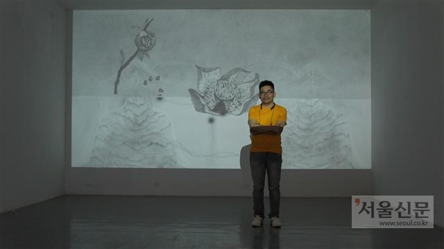 중국 베이징의 대안 공간 ‘드 아트센터’를 연 큐레이터 샤옌궈가 한국 작가 이승애의 작품 앞에 서 있다.