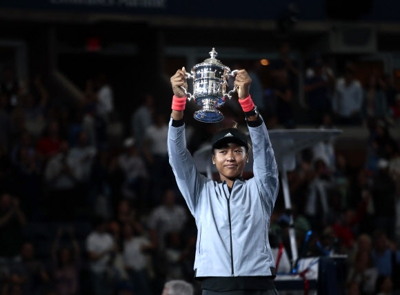 오사카 나오미가 9일 미국 뉴욕의 빌리 진 킹 내셔널 테니스센터에서 열린 US오픈 테니스대회에서 일본 선수로는 최초로 메이저 대회 단식 우승을 차지한 뒤 시상식에 참석해 트로피를 번쩍 들어 올리고 있다. 뉴욕 AP 연합뉴스