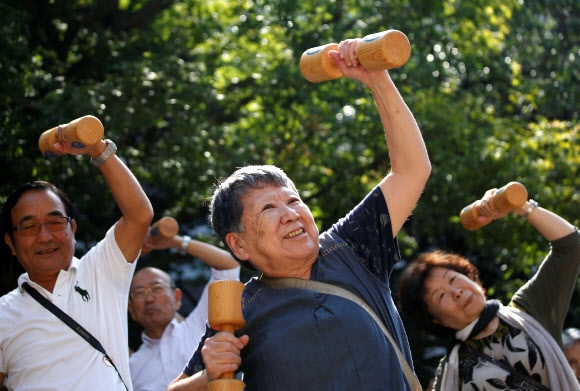 초고령사회로 진입한 일본 노인들이‘경로의 날’을 맞아 도쿄 스가모의 한 사원 공터에서 나무 아령을 들고 운동을 하고 있다. 도쿄 로이터 연합뉴스