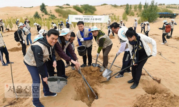 18일  중국 네이멍구(內蒙古)쿠부치 사막의 조림지’대한항공 생태원’에서 황사방지를 위한 나무심기 봉사 활동에 참여한 대한항공 임직원들과 중국 현지 관계자들이 나무를 심고 물을 주며 즐거워 하고 있다. 2018. 9. 18 쿠부치=안주영 기자 jya@seoul.co.kr