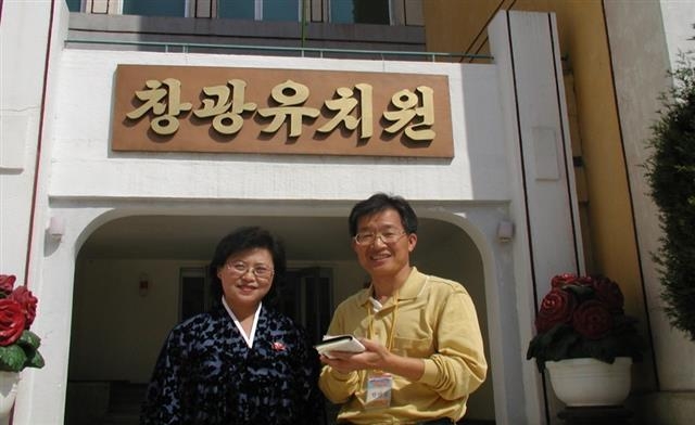 한만길(오른쪽) 한국교육개발원 석좌연구교수가 2003년 평양의 창광유치원을 방문해 유치원 관계자와 활짝 웃고 있다.  한만길씨 제공