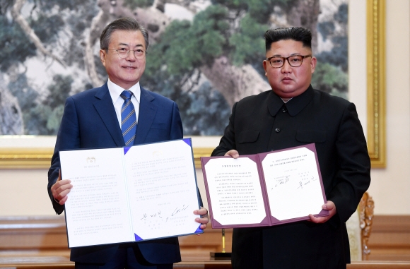 문재인 대통령과 김정은 국무위원장이 19일 백화원 영빈관에서 정상회담을 마친 뒤 평양공동선언서에 서명한 뒤 펼쳐 보이고 있다. 2018.9.19 /평양사진공동취재단