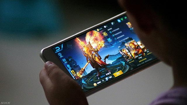 게임을 하느라 핸드폰 화면에 몰두 하고 있는 중국의 한 청소년. NHK 웹사이트