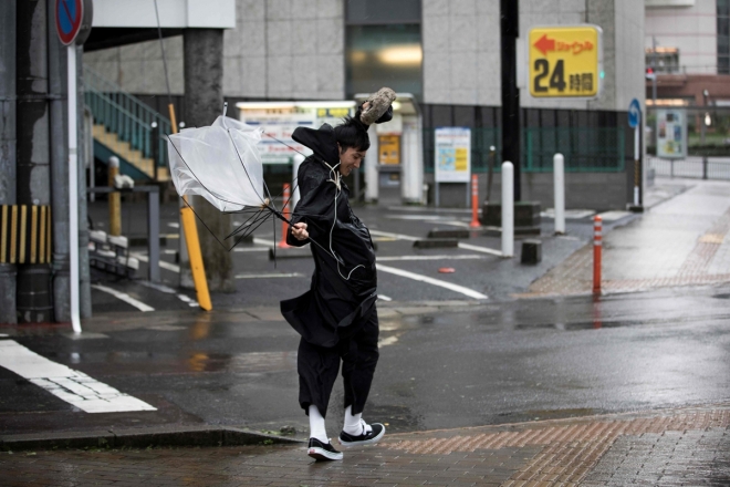 초강력 태풍 ‘짜미’(Trami)가 일본 열도를 강타한 가운데 지난달 30일 규슈 가고시마현에 사는 한 남성이 우산을 놓치지 위해 안간힘을 쓰고 있는 모습. AFP 연합뉴스