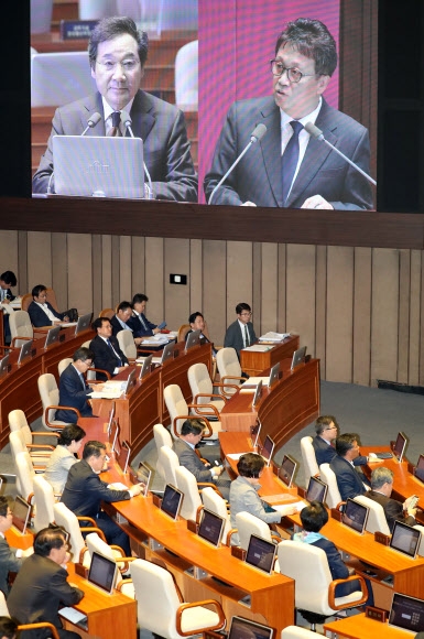 2일 국회 경제 분야 대정부질문에서 이낙연(왼쪽) 국무총리가 민병두 더불어민주당 의원의 질의를 듣고 있는 모습이 본회의장 벽에 걸린 대형 스크린에 나오고 있다.  연합뉴스