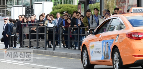 18일 서울역 앞 택시승강장에서 출근길 시민들이 택시를 기다리고 있다. 이날 택시업계는 카카오의 카풀 서비스 진출에 반대하며 ‘택시 생존권 사수 결의대회’를 열고 24시간 파업에 돌입했다.  이종원 선임기자 jongwon@seoul.co.kr