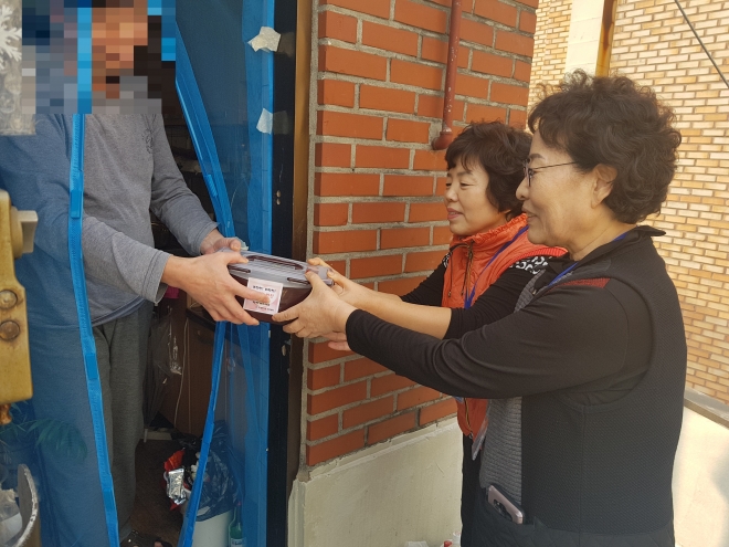 서울 동작구 노량진1동 자원봉사자들이 홀로 사는 이웃에게 정성껏 만든 반찬을 전해주고 있다. 동작구 제공