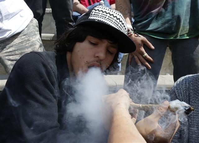 지난 4월 미국 콜로라도 덴버에서 열린 마리화나 축제에서 한 청년이 음악을 들으며 마리화나를 피우고 있다.  덴버 AP 연합뉴스