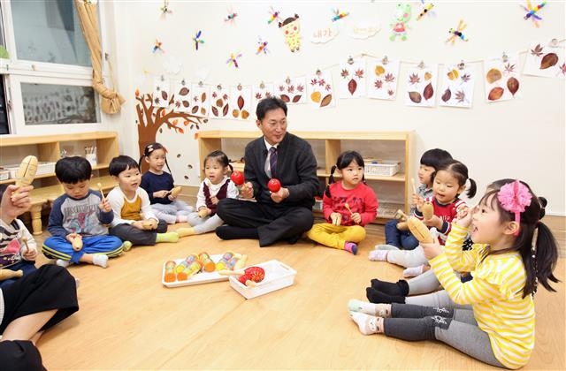 최근 사립유치원 비리가 큰 파장을 일으키는 가운데 동작구가 공교육 확대를 위해 국공립 어린이집을 잇따라 개원하면서 주목받고 있다. 사진은 이창우 동작구청장이 지난해 11월 구청 내 어린이집에서 아이들과 함께 어울리는 모습.  동작구 제공