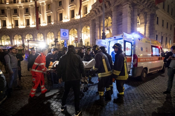 이탈리아 구조대원들이 23일 로마 리퍼블리카 지하철역 에스켈레이터 사고로 다친 러시아 프로축구 CSKA 모스크바 서포터들을 병원으로 후송하고 있다. 로마 AP 연합뉴스 