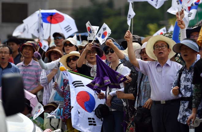 서울 광화문사거리에서 보수단체 회원들이 태극기를 흔들며 구호를 외치고 있다. 2018.8.15 박지환기자 popocar@seoul.co.kr