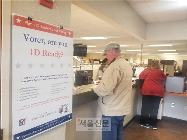 26일(현지시간) 미국 버지니아 제7지역구인 리치먼드 인근 헨리코카운티의 유권자 등록소·부재자 투표소를 찾은 지역 주민들이 유권자 등록과 부재자 투표를 위해 서류를 작성하고 있다.