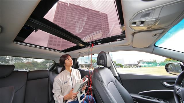 현대기아차 연구원이 2세대 솔라루프가 설치된 자동차 안에서 효율을 측정하고 있다. 현대기아차 제공