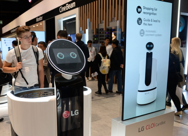 지난해 9월 독일에서 열린 ‘국제가전전시회(IFA) 2018&#65279;’에서 관람객들이 ‘LG 클로이 카트봇’을 살펴보고 있다. LG전자 제공 　
