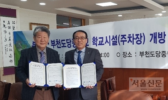 민승용(오른쪽) 부천시 교육사업단장과 진병구 도당중학교장이  ‘학교시설(주차장) 개방 업무협약’을 맺었다. 부천시 제공 
