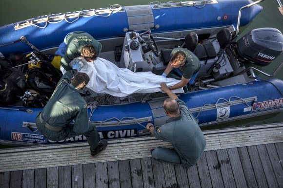 스페인 해경이 6일(현지시간) 바르베트 해안에서 발견한 난민의 시신을 옮기고 있다.=AP 연합뉴스