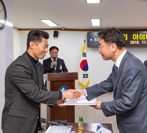 김선갑(오른쪽) 서울 광진구청장이 8일 아이디어뱅크 우수제안자 시상식에서 최우수상을 받은 주민에게 상장을 수여하고 있다. 광진구 제공