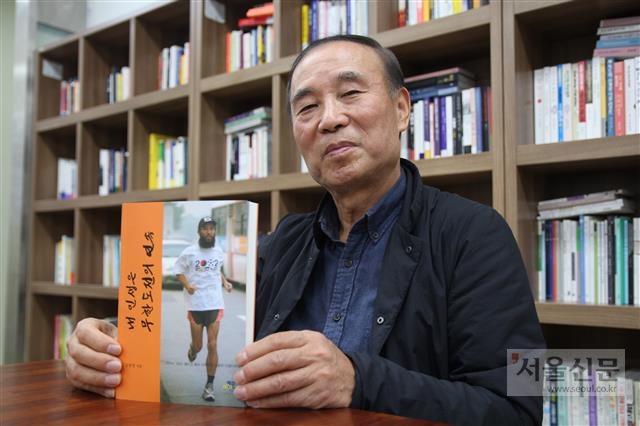 한국에서 월드컵이 열린다는 소식을 알리기 위해 세계를 누볐던 월드컵 마라토너 김홍영씨가 8일 당시를 회고한 자서전을 들어보이며 미소를 짓고 있다.