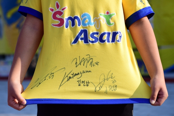 아산 무궁화 축구단의 한 어린이 팬이 선수들의 사인이 써진 유니폼을 자랑스럽게 펼쳐보이고 있다. 2018. 11. 5 정연호 기자 tpgod@seoul.co.kr