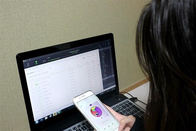 인기 아이돌 그룹의 팬인 차모양이 노트북과 휴대전화를 이용한 음원 듣기(스트리밍)를 통해 순위 높이기 ‘총공’에 나선 모습.  독자 제공