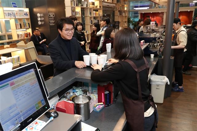 정원오(왼쪽) 성동구청장이 성동미래일자리주식회사의 카페 2호점인 구청 ‘책마루 카페’에서 커피를 주문하고 있다. 성동구 제공