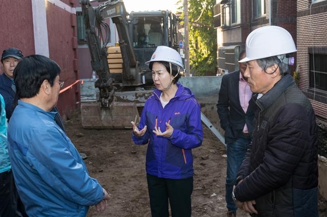 김수영(왼쪽) 양천구청장이 지난달 19일 붕괴 옹벽 복구 현장을 찾아 공사 진행 상항을 점검하고 있다.  양천구 제공