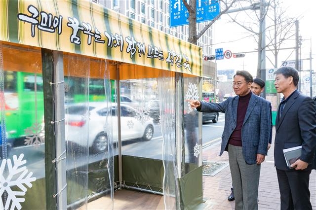 김선갑 서울 광진구청장이 18일 구청 앞 버스정류장에 새로 설치한 ‘찬바람막이 한파쉼터’를 둘러보고 있다.  광진구 제공