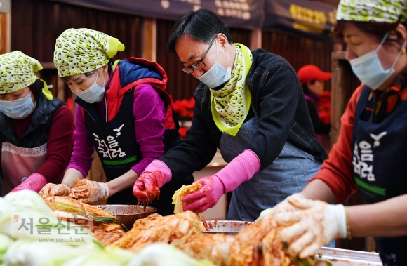 유성훈 서울 금천구청장이 지난 18일 오전 대명 여울빛 거리시장 광장에서 열린 전통시장 김장나눔 행사에서 시장 상인들과 함께 김장을 하고 있다. 박윤슬 기자 seul@seoul.co.kr