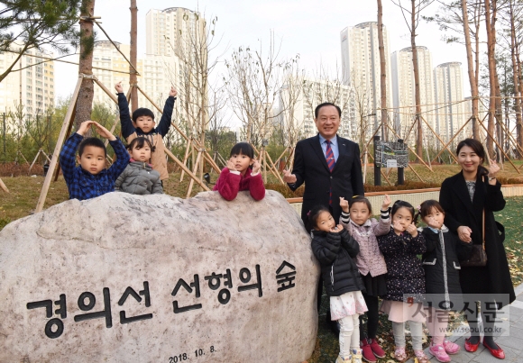 유동균 서울 마포구청장이 최근 완공된 마포구 중동 경의선 선형의 숲에서 이 일대로 체험학습을 나온 유치원생들과 만나고 있다. 지난달 선형의 숲 조성 공사가 마무리됨에 따라 성산자동차 운전전문학원부터 MBC 본사까지 약 1㎞ 구간의 푸른 산책길을 즐길 수 있게 됐다. 유 구청장은 완공 행사에서 미세먼지 대응을 위한 지역 내 유휴지 26곳에 나무 100만그루를 심는 공기청정숲 조성 4개년 마스터플랜을 발표한 바 있다. 최해국 선임기자 seaworld@seoul.co.kr