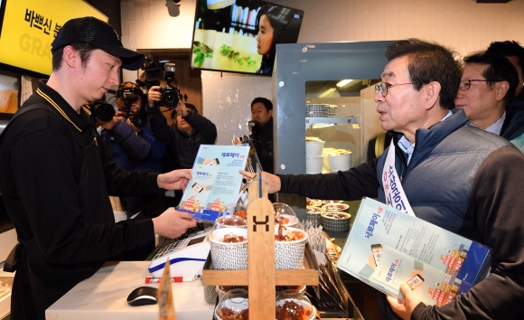 박원순 서울시장이 22일 서울 서대문구 연세로의 한 상점에서 제로페이 홍보를 하고 있다. 소상공인 간편결제 서비스 ‘제로페이’는 소비자가 결제하면 카드사나 VAN사업자 등 중간 결제사를 거치지 않고 소비자 계좌에서 판매자 계좌로 금액이 바로 이체돼 수수료를 줄일 수 있다. 2018. 11. 22. 박윤슬 기자 seul@seoul.co.kr