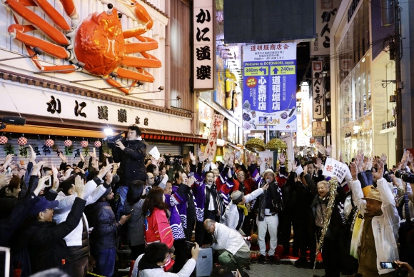 일본 열도가 24일 도쿄올림픽에 이어 2025년 오사카 세계박람회 유치로 온통 흥분의 도가니에 휩싸였다. 사진은 이날 새벽 1시쯤 박람회 유치 소식이 전해지자 오사카 시민들이 환호하고 있는 모습. 오사카 AP 연합뉴스