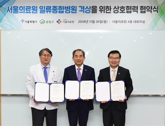 류경기 서울 중랑구청장이 지난 26일 서울의료원에서 열린 업무 협약식에서 기념촬영을 하고 있다. 왼쪽부터 김민기 서울의료원장, 윤중병 서울시 행정1부시장, 류 구청장.  중랑구 제공