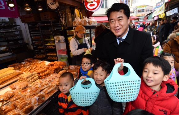 지난 23일 서울 관악구 인헌시장에서 열린 ‘유아 전통시장 나들이 체험’을 찾은 박준희 관악구청장이 인근 어린이집 아이들과 어울리며 장보기를 돕고 있다. 박지환 기자 popocar@seoul.co.kr