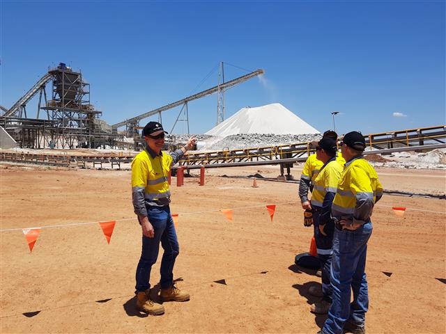 켄 브린스덴(왼쪽) 필바라 미네랄스 최고경영자(CEO)가 호주 필바라 지역의 필간구라 광산에서 리튬 광석의 가공 공정을 설명하고 있다. 하얀 산처럼 쌓여 있는 리튬 원광은 분쇄와 선별 공정을 거쳐 순도 높은 리튬 정광 제품으로 만들어진다.  포스코 제공