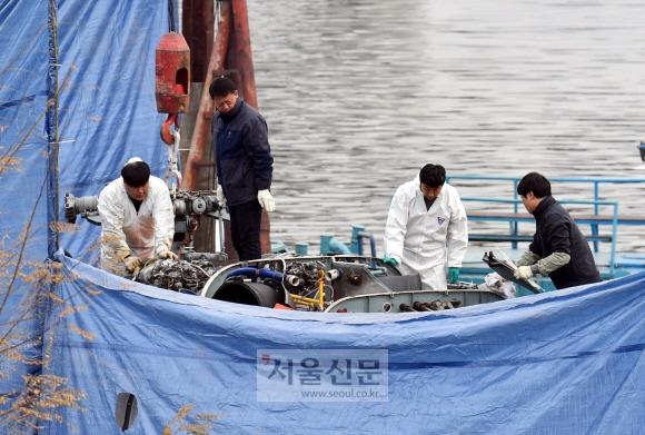 전날 산불 진화 작업을 하다 한강에 추락해 경기도 구리시 암사대교 북단 둔치로 인양된 산림청 헬기를 2일 관계자들이 해체하고 있다. 해체 완료된 헬기 잔해 및 본체는 국토교통부 항공조사위원회로 이송된다. 2018. 12. 2.  박윤슬 기자 seul@seoul.co.kr