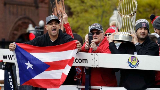 알렉스 코라 보스턴 감독이 지난 9월 보스턴에서 진행된 월드시리즈 우승 환영 행사 도중 조국 푸에르토리코 국기를 들어 보이고 있다. AP 자료사진
