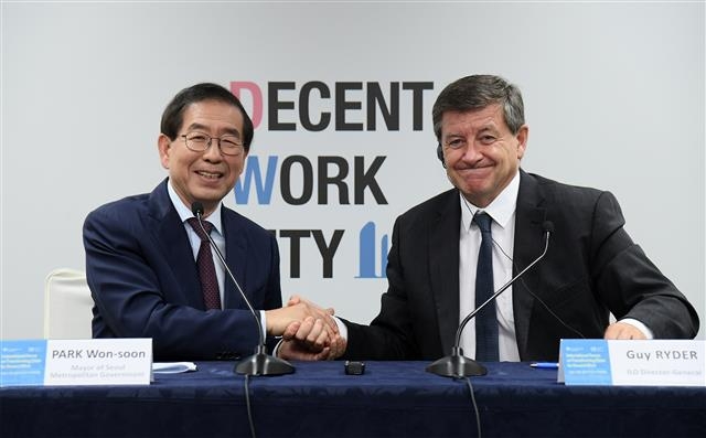 박원순(왼쪽) 서울시장이 지난해 열린 제1회 좋은 일자리 도시 국제포럼에서 가이 라이더 국제노동기구(ILO) 사무총장과 도시정부 단위의 일터 불평등 해법 모색을 위한 국제 협의체를 창립하기로 결의한 뒤 손을 맞잡고 있다.  서울시 제공