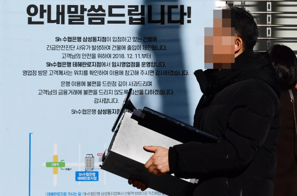 12일 붕괴위험 진단을 받은 서울 삼성동 대종빌딩에서 입주자들이 짐을 들고 나오고 있다.  2018. 12. 12 정연호 기자 tpgod@seoul.co.kr